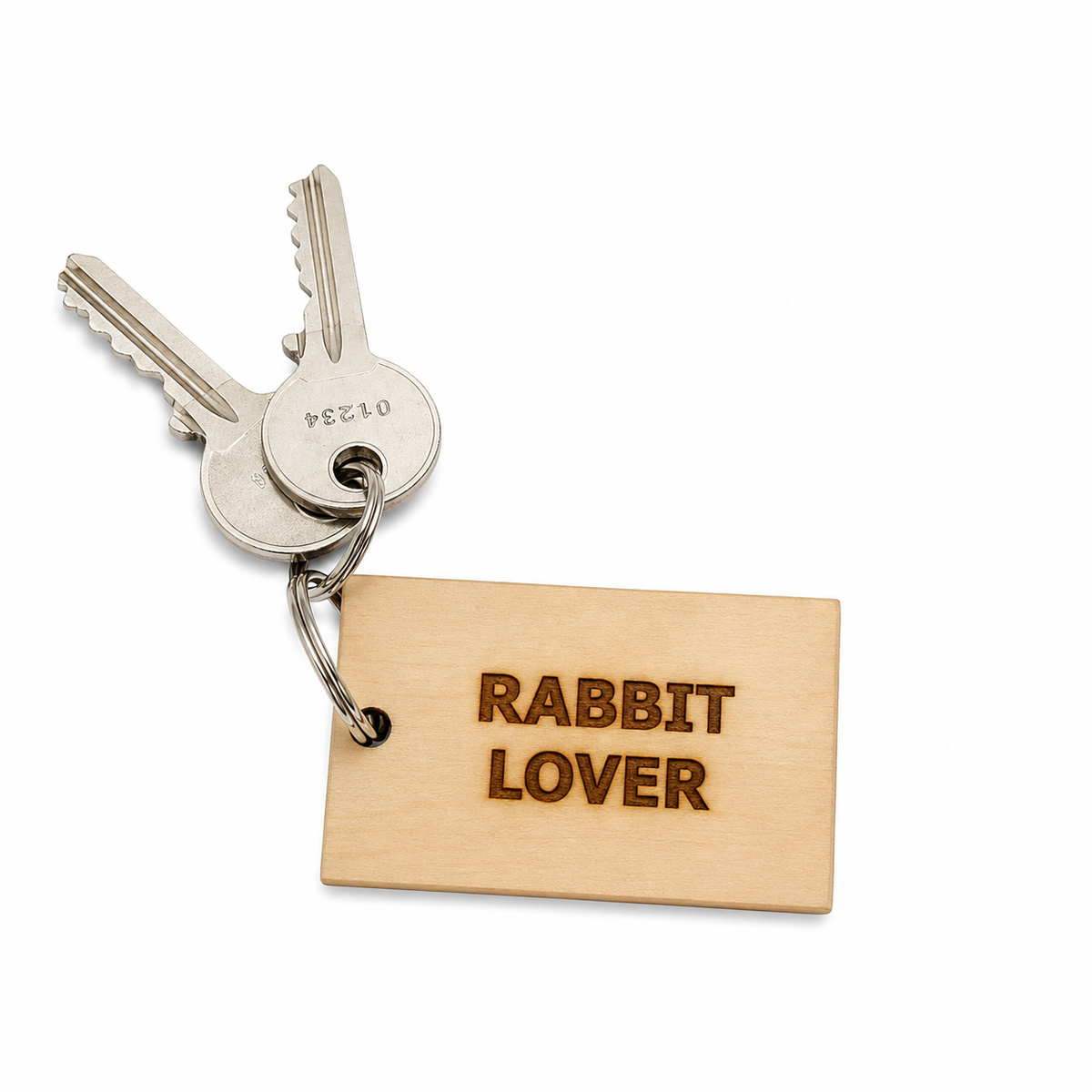 A rectangular light wood keychain tag engraved with 'RABBIT LOVER' in a dark brown tone, attached to a metal keyring with two silver keys on a clean white background.