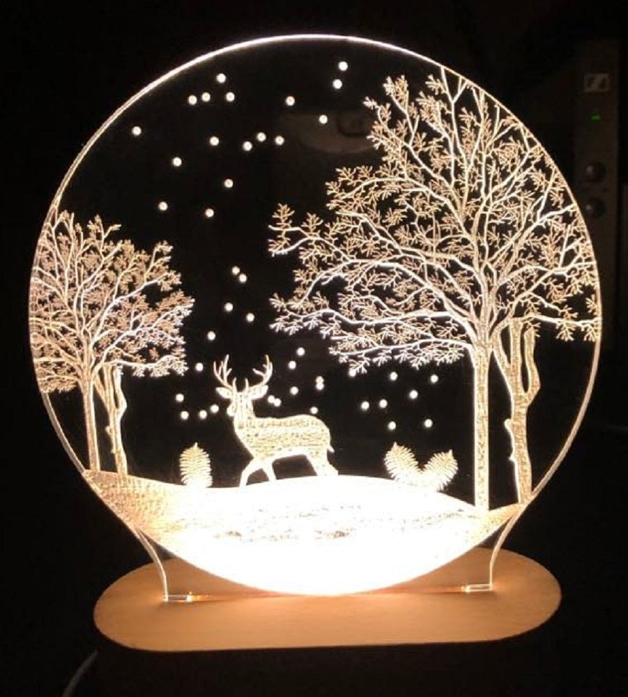 Decorative night light with a deer and tree design on a black background