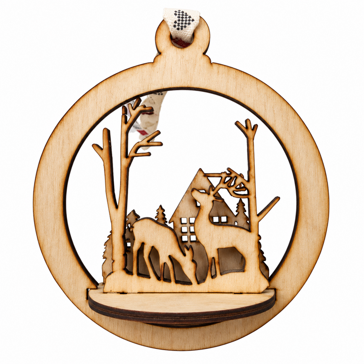 A circular laser-cut wooden ornament featuring a winter scene with two deer, bare trees, a small house, and a hanging loop at the top, shown on a plain white background.