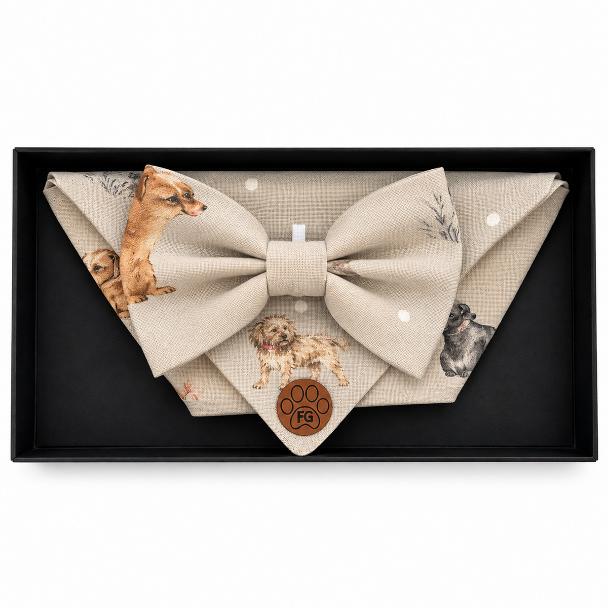A beige fabric bow tie and matching pocket square set with dog illustrations, presented in a black gift box. The pocket square features a brown paw print with the brand name 'Paw Design' inside it.