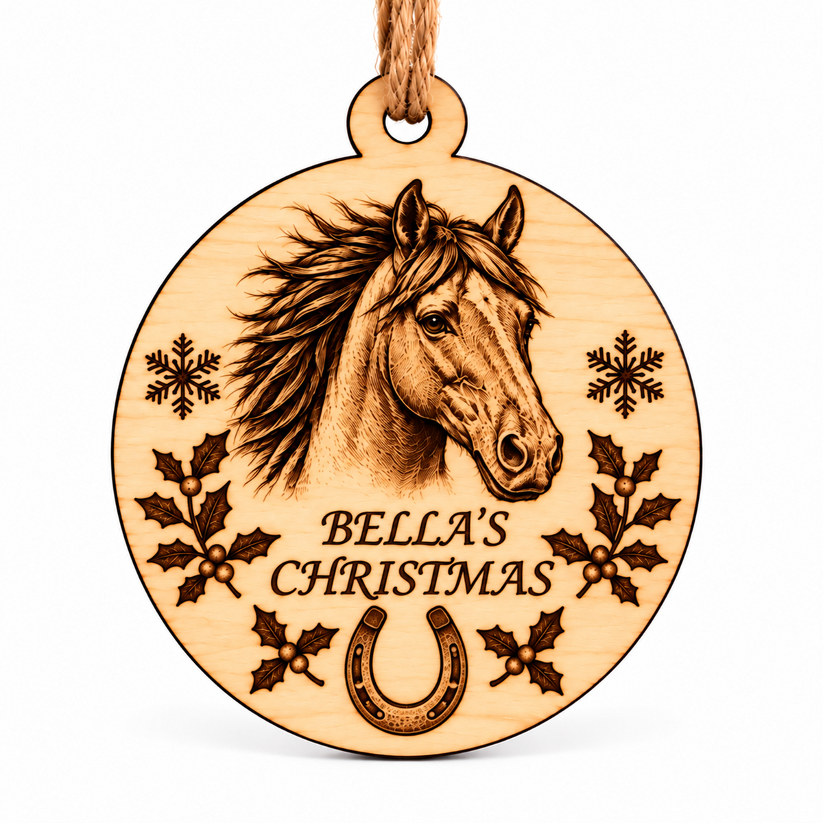 A round wooden Christmas ornament engraved with a horse head, the text 'BELLA'S CHRISTMAS,' snowflakes, holly leaves, and a horseshoe, hanging from a natural wood string on a white background.