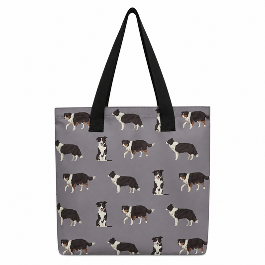 A grey tote bag with black shoulder straps, featuring an all-over repeating pattern of black, white, and tan dog illustrations, shown against a plain white background.