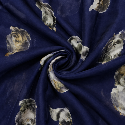 A close-up of a navy blue fabric draped in a spiral, featuring a scattered print of cat faces in grey, white, and beige tones.