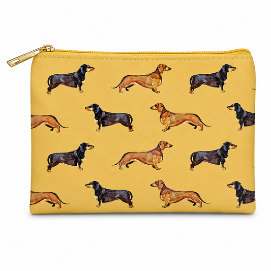 A mustard zipped cosmetic bag featuring a repeating pattern of dachshund dogs in tan and black, with a gold zipper and pull tab, shown on a plain white background.