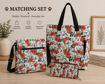Three matching tote and bag sizes displayed together on a tabletop with a decorative book, framed print, and plant. The bags have a white background with an allover print of red roses and black-and-white Dalmatian dogs.