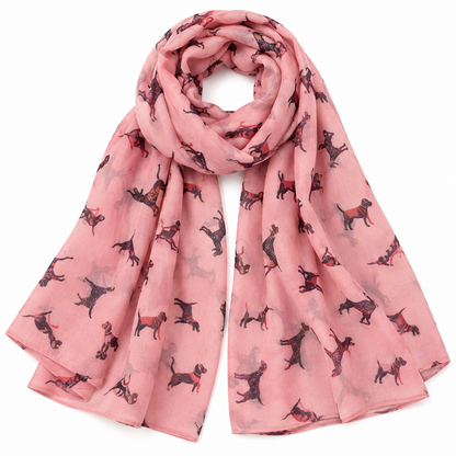 A pink scarf featuring an all-over print of small black and brown dog silhouettes, arranged in a loose loop against a plain white background.
