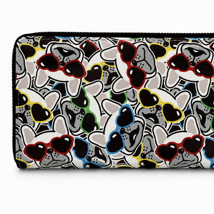 A zip-around wallet with an all-over cartoon French Bulldog faces and sunglasses pattern in black, white, grey, red, yellow, blue, and green on a white background.