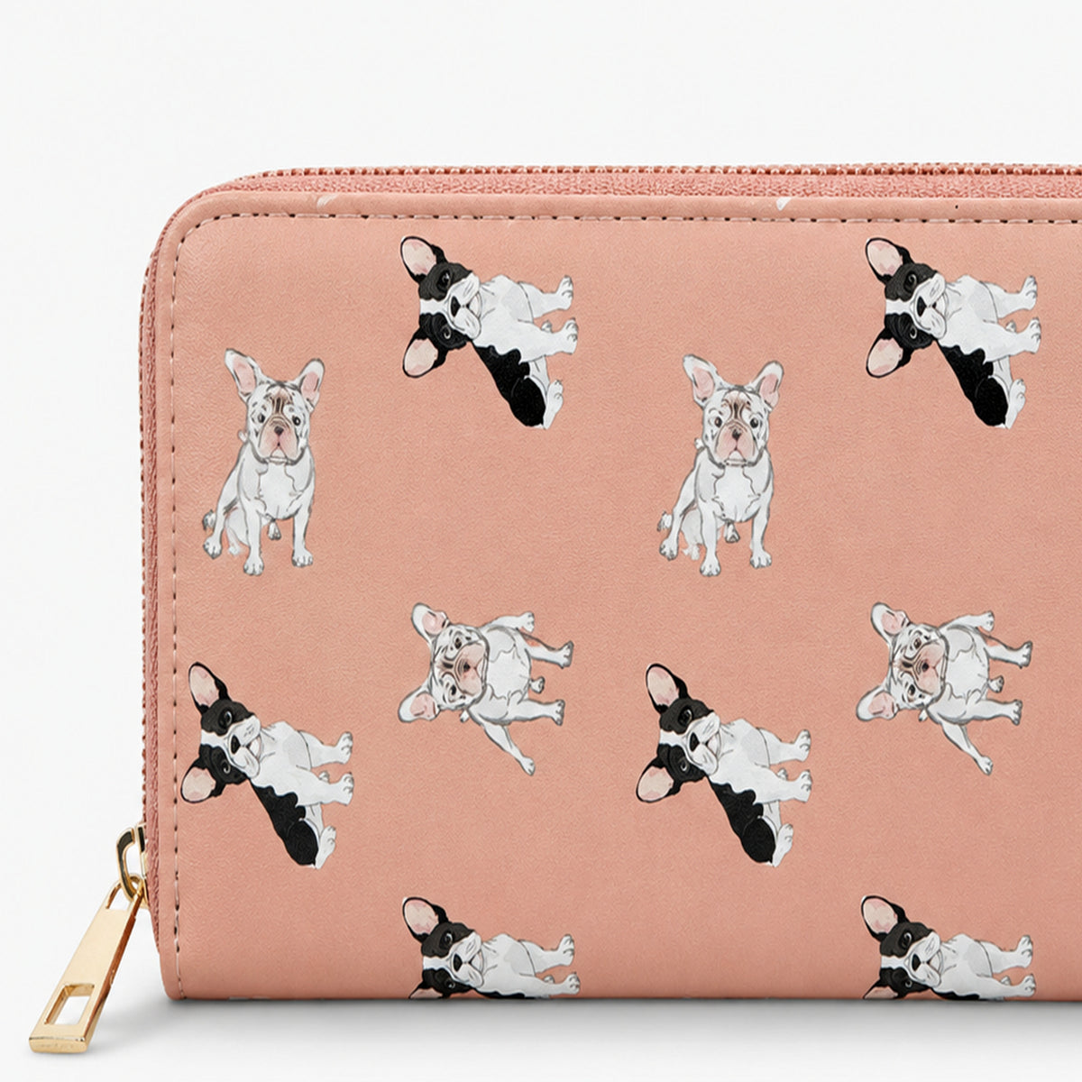 A zip-around wallet in dusty pink faux leather featuring a repeating pattern of French Bulldog illustrations in black, white, and pink, with a gold zipper pull.