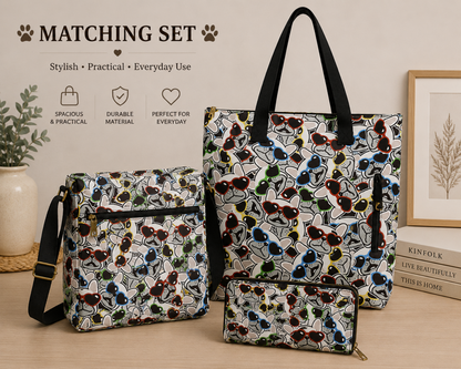 Three matching tote and shoulder bags in a coordinated multicolour French Bulldog print set, displayed on a tabletop with decorative props and promotional text reading 'MATCHING SET'. The bags feature an abstract line pattern in black, white, blue, green, red, and yellow, with black handles and straps.