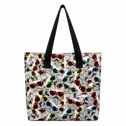 A tote bag with black shoulder straps, featuring a dense cartoon graphic print of stylised French Bulldog faces wearing red, black, blue, green, and yellow sunglasses on a light background.