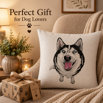 A square beige cushion cover with a printed husky sits on a cosy armchair in a warmly lit living room. A wrapped gift box with paw-print patterns is in the foreground, and the text 'Perfect Gift for Dog Lovers' appears at the top left.