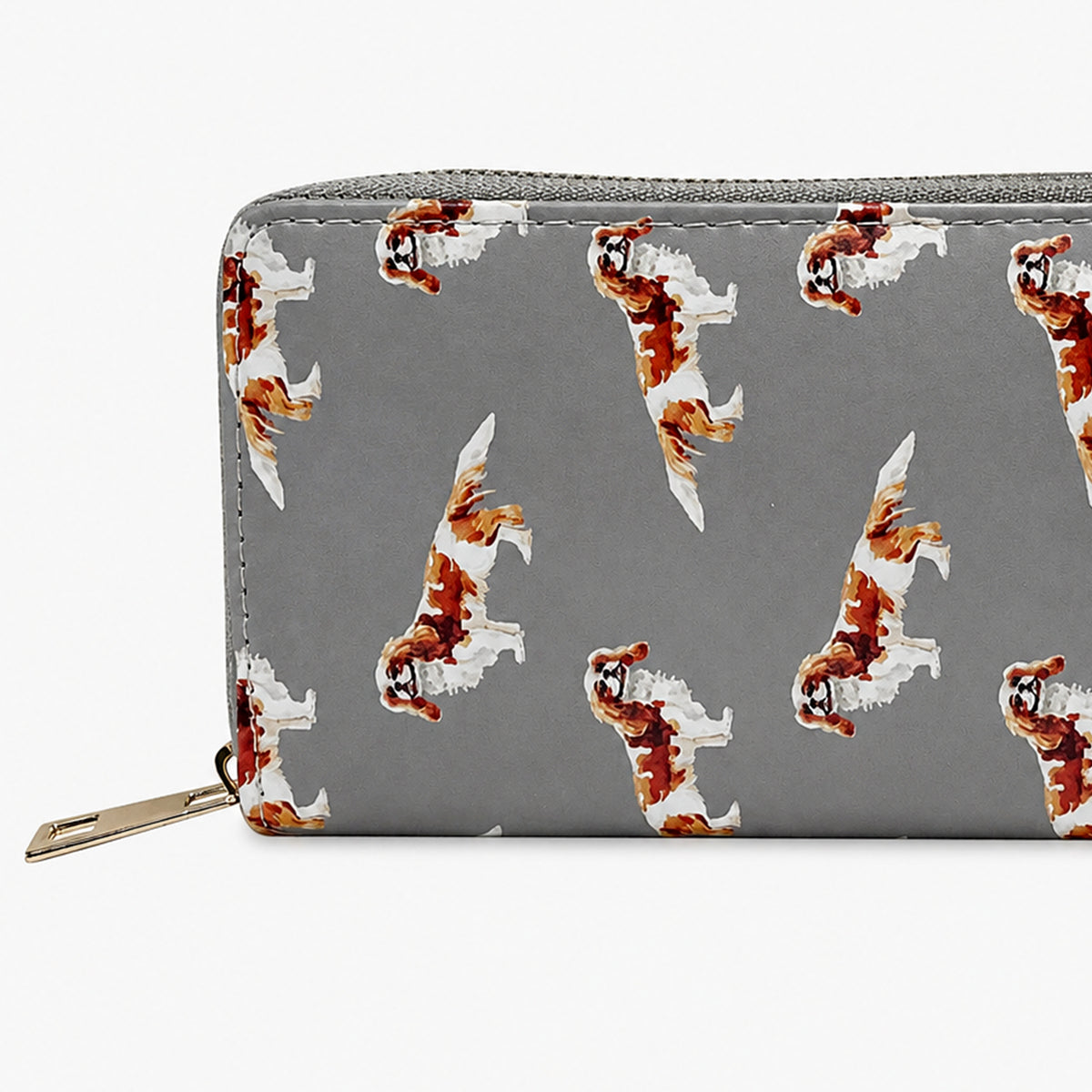 A grey zip-around wallet with a repeating pattern of brown and white King Charles Cavalier Spaniel dog illustrations, shown against a plain white background.