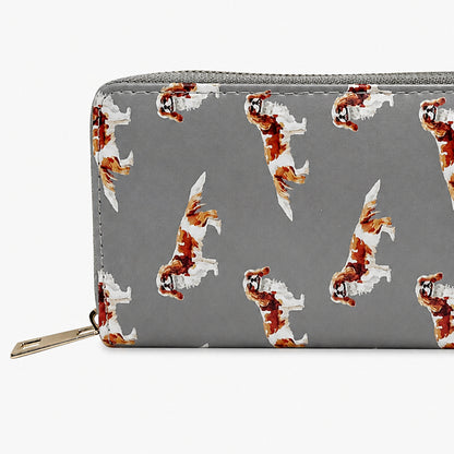 A grey zip-around wallet with a repeating pattern of brown and white King Charles Cavalier Spaniel dog illustrations, shown against a plain white background.