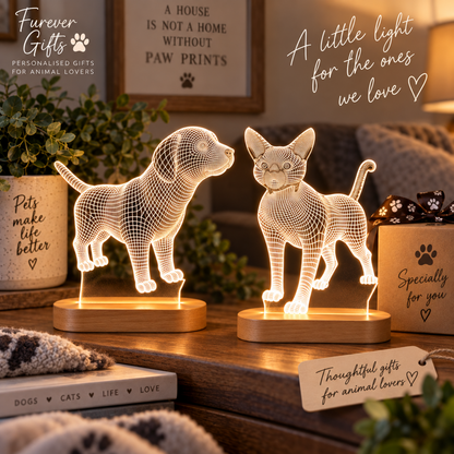 Two 3D LED lamp designs shaped like a dog and a cat, glowing with warm light on wooden bases, displayed on a table in a cozy home setting with decorative signs and plants.