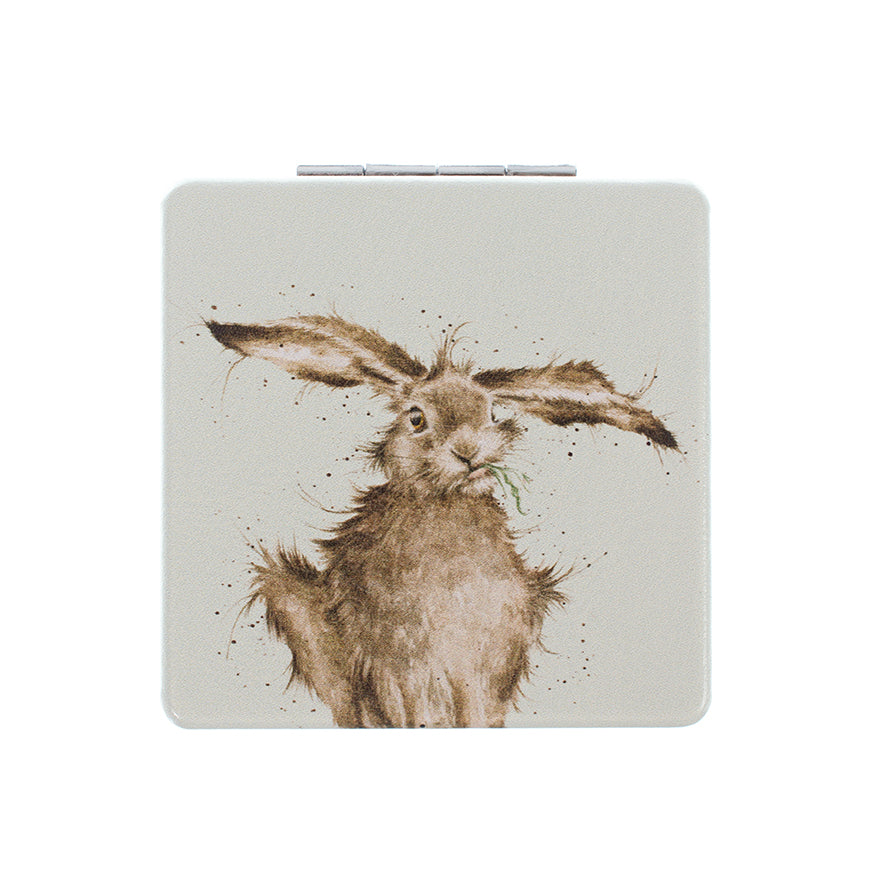 A square compact case featuring a watercolor-style illustration of a hare in brown and beige tones on a light gray background, shown against a plain white studio background.