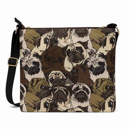 A square shoulder bag with a black adjustable strap and gold-tone hardware, featuring an all-over print of illustrated pug dog faces in shades of brown, beige, and cream on a white background.