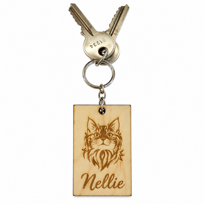 A personalised wooden keychain featuring a laser-engraved cat portrait and the name 'Nellie', attached to a metal keyring with two keys, shown on a plain white background.