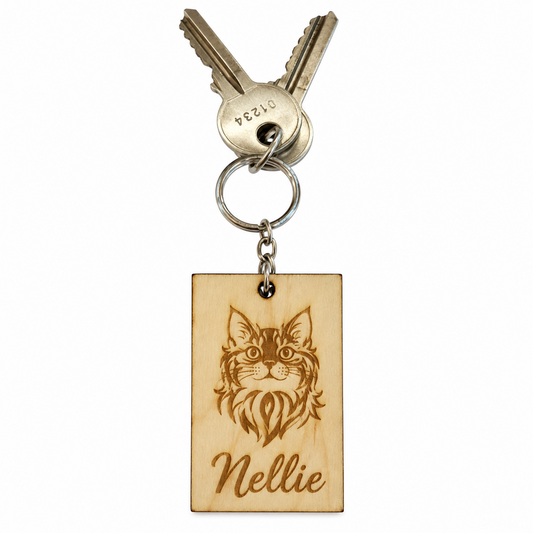 A personalised wooden keychain featuring a laser-engraved cat portrait and the name 'Nellie', attached to a metal keyring with two keys, shown on a plain white background.