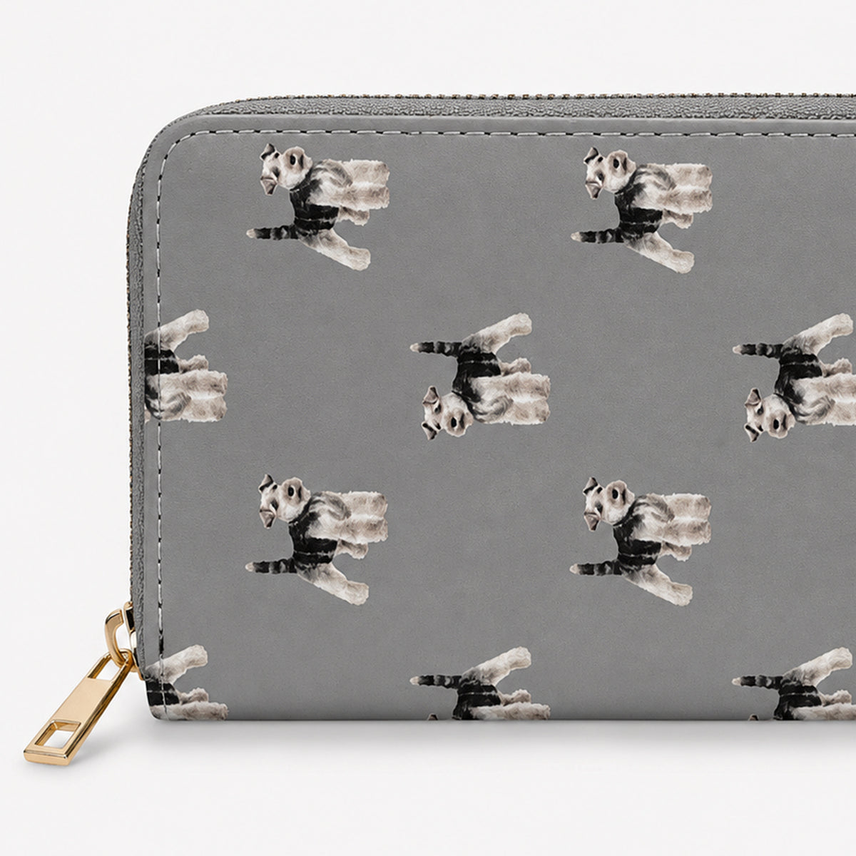 A grey zip-around wallet with a repeating print of Schnauzer  dogs in black, white, and grey, featuring a gold-tone zipper pull on a light grey background.