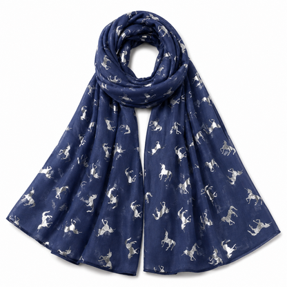 A denim blue scarf with a repeating pattern of silver unicorn silhouettes, draped in a loop on a plain white background.