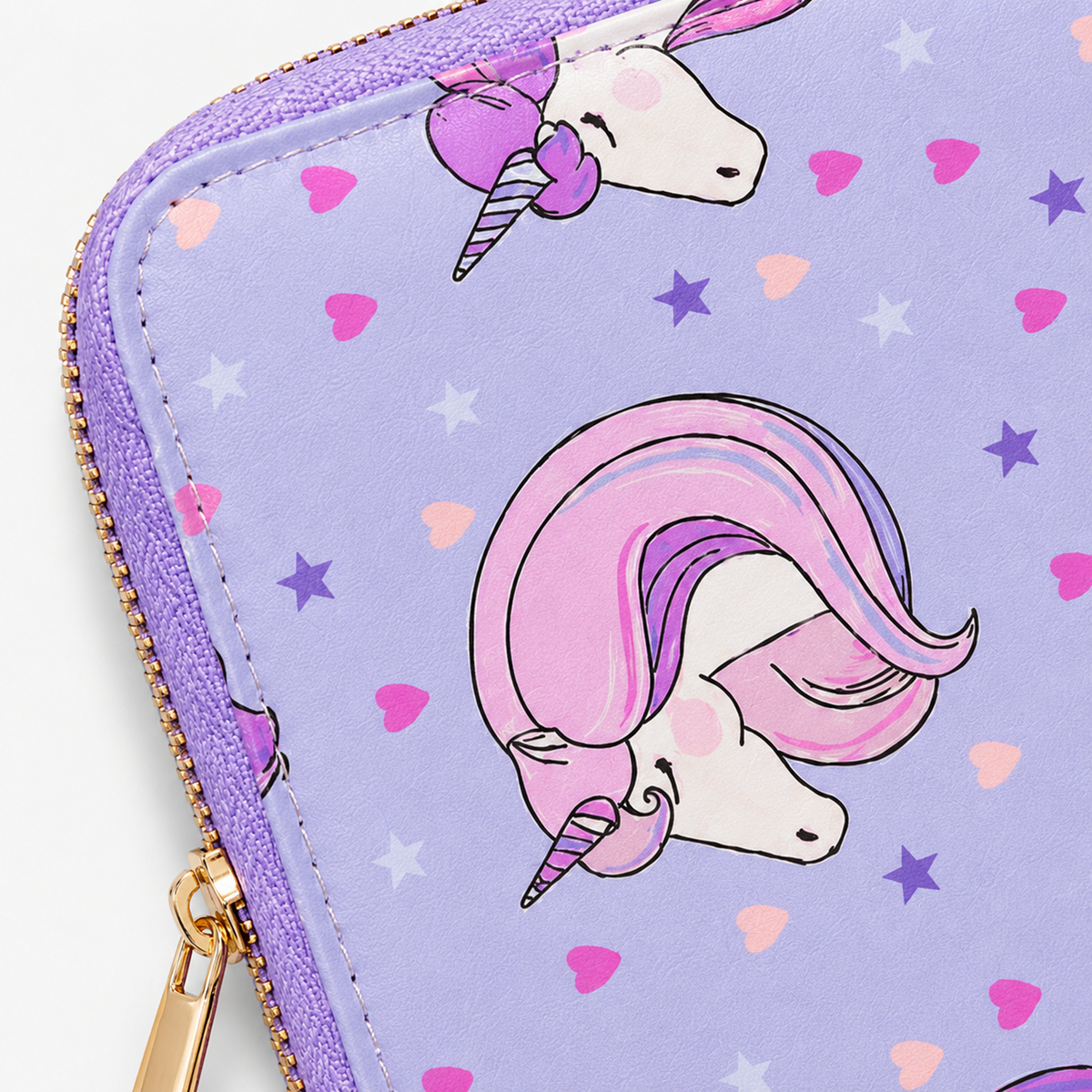 A close-up of a lavender zippered pouch or wallet featuring a repeating cartoon unicorn print in pink, purple, white, and light blue, with a gold zipper.