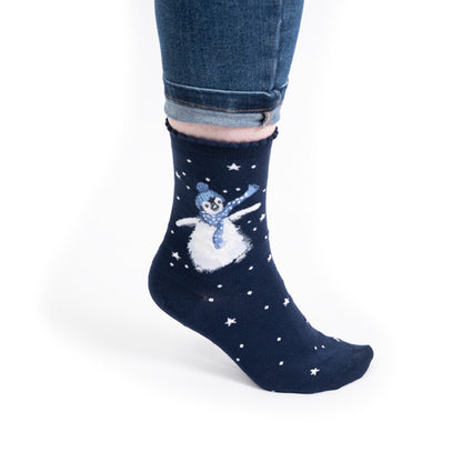 Navy blue sock with a snowman design worn by a person on a white background