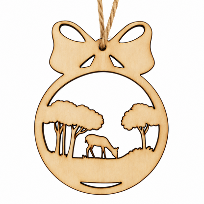 A natural wood Christmas ornament shaped like a round bauble with a bow at the top, featuring a laser-cut landscape scene with trees and a deer, hanging from a twine string on a white background.