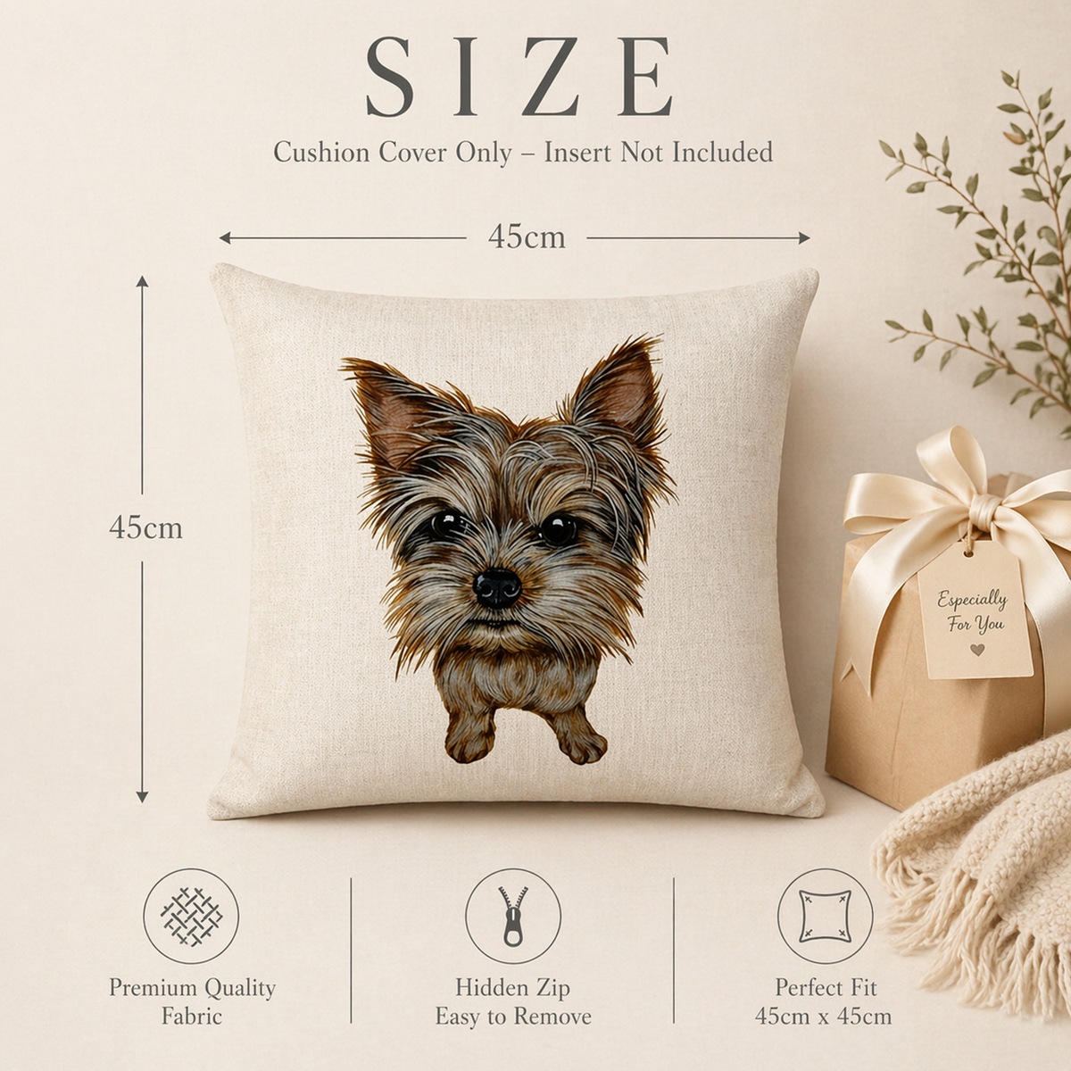 A square beige cushion cover with a printed illustration of a small Yorkshire Terrier dog, shown with dimension labels indicating 45cm by 45cm. The image includes marketing text, fabric quality icons, zipper detail icon, and fit information, plus a wrapped gift and fringe fabric as styled props on a warm cream background.