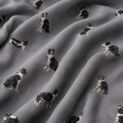 Grey scarf with a repeating print of black, white, and tan Border Collie dogs, shown in soft folds.