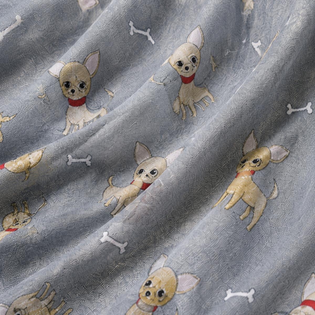A close-up of draped grey scarf printed with cartoon Chihuahua dogs wearing red collars, white bones, and small dog silhouettes.
