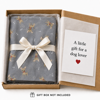 A folded grey scarf gift item with a small Chihuahua dog print and white bow, presented in a kraft gift box next to a card that reads 'A little gift for a dog lover' with a red heart. A note at the bottom says 'GIFT BOX NOT INCLUDED'.