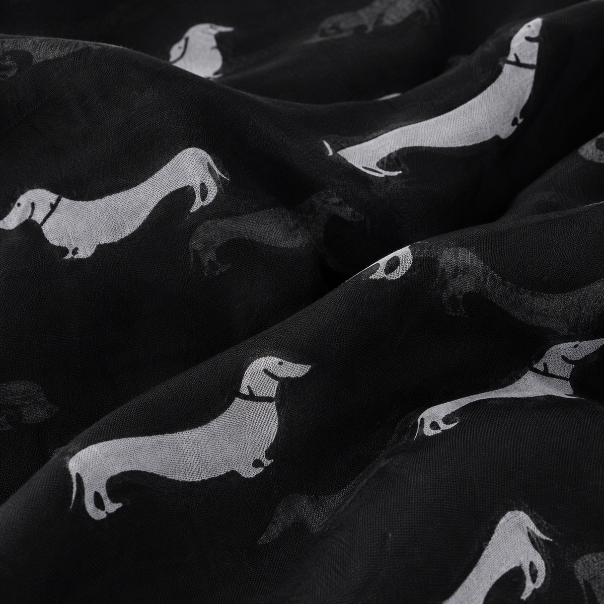 Black scarf with a repeating pattern of white dachshund dog silhouettes, shown in a close-up draped view.
