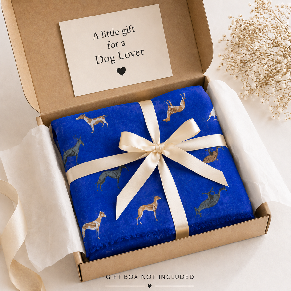 A folded royal blue ladies scarf with a cream ribbon and bow, presented in a kraft gift box with a card that reads 'A little gift for a Dog Lover'.