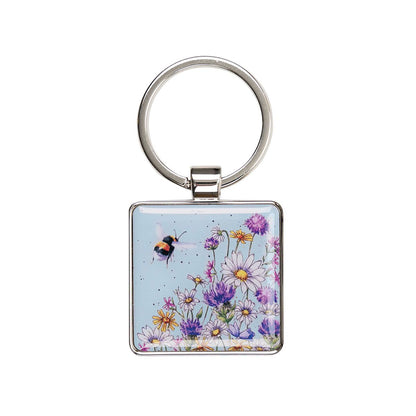 Keychain with a design of flowers and a bee on a light blue background