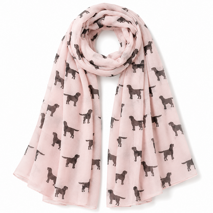 A light pink scarf with an all-over print of black Labrador dog silhouettes, styled in a loop on a white background.