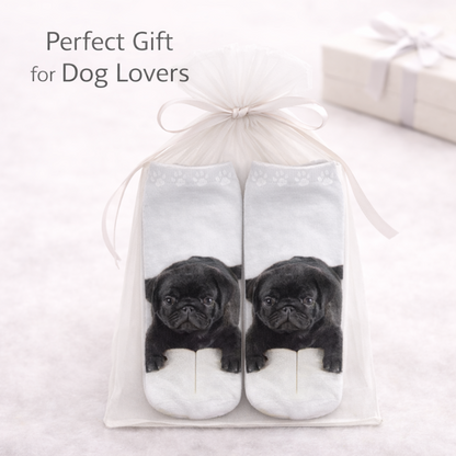 A pair of white ankle socks with a printed black pug puppy design, presented in a clear gift bag with a white ribbon. The text 'Perfect Gift for Dog Lovers' is displayed in the upper left corner.