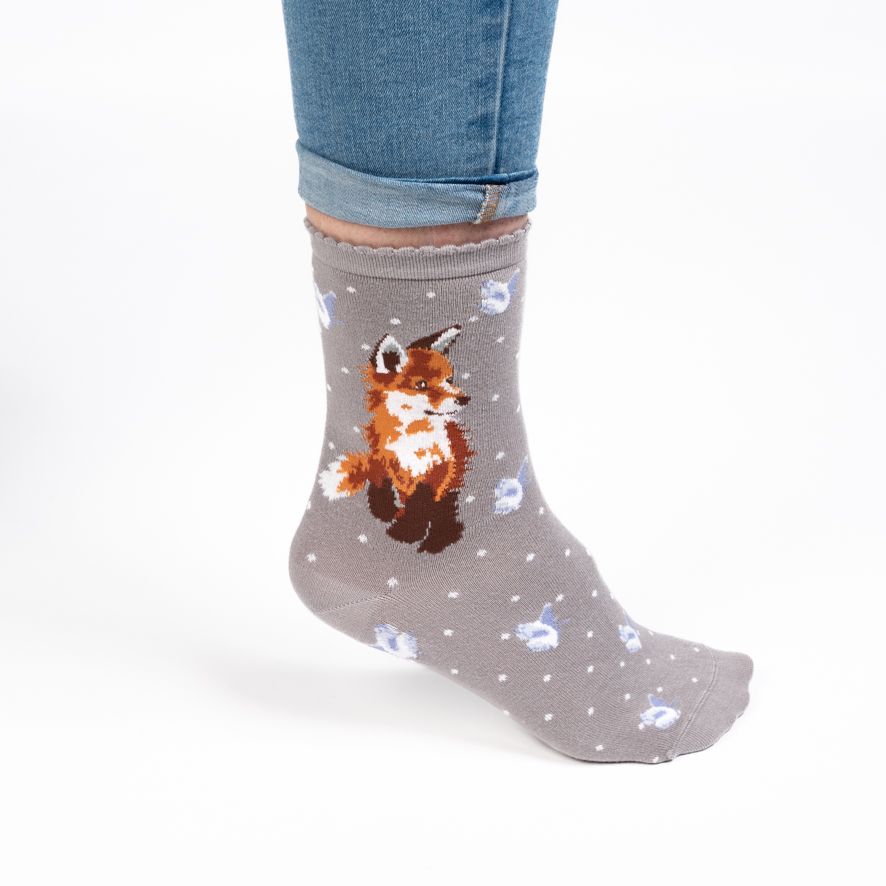 Gray sock with a fox design worn by a person on a white background