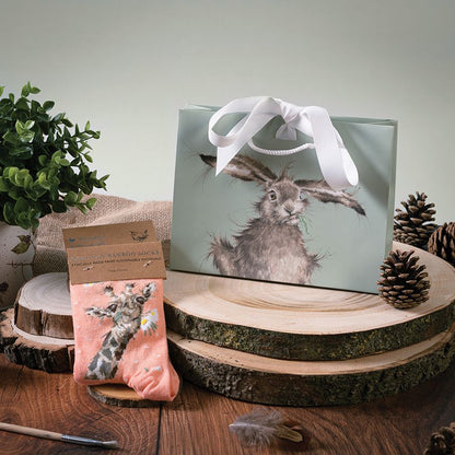 Gift bag with rabbit design on a wooden surface with decorative elements
