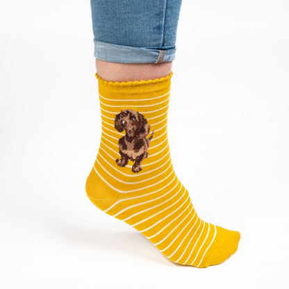 Yellow striped sock with a dog design worn by a person on a white background