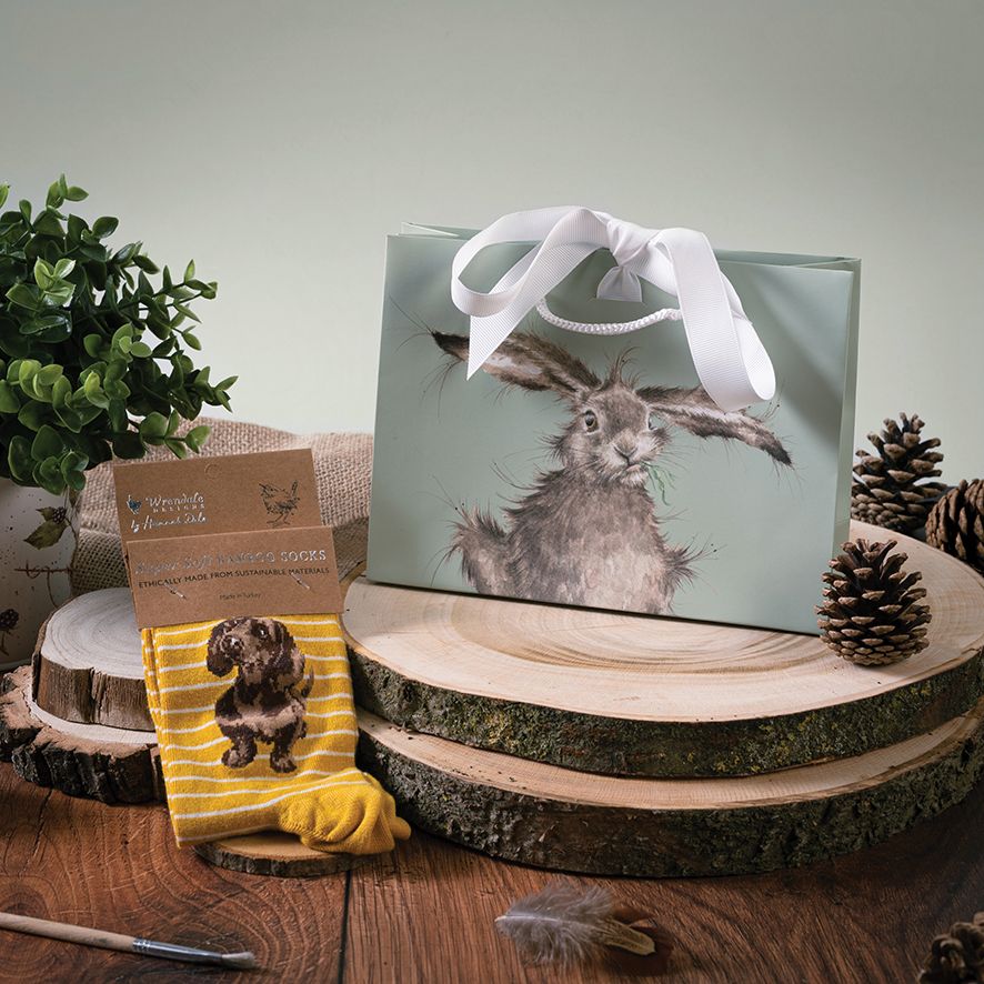 Gift bag with a rabbit design on a wooden surface with decorative elements.