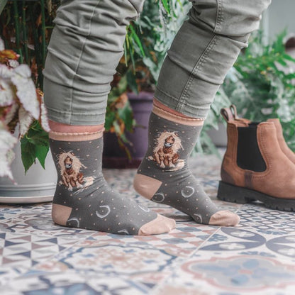 Person wearing socks with horse designs on a patterned floor.