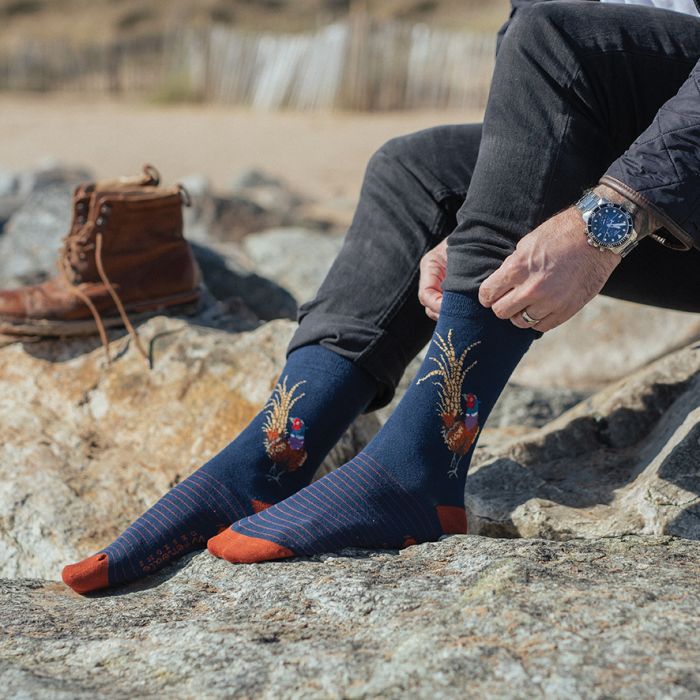 Person wearing blue socks with floral designs outdoors on rocks