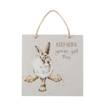 Hanging sign with a rabbit illustration and motivational text on a white background