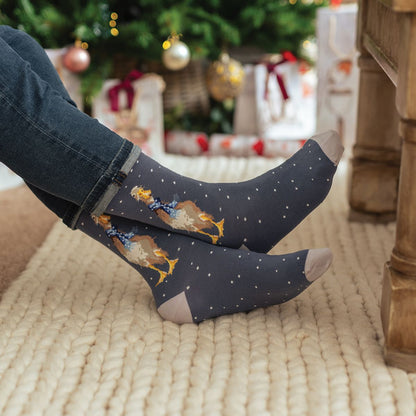 Person wearing festive socks with a Christmas-themed background